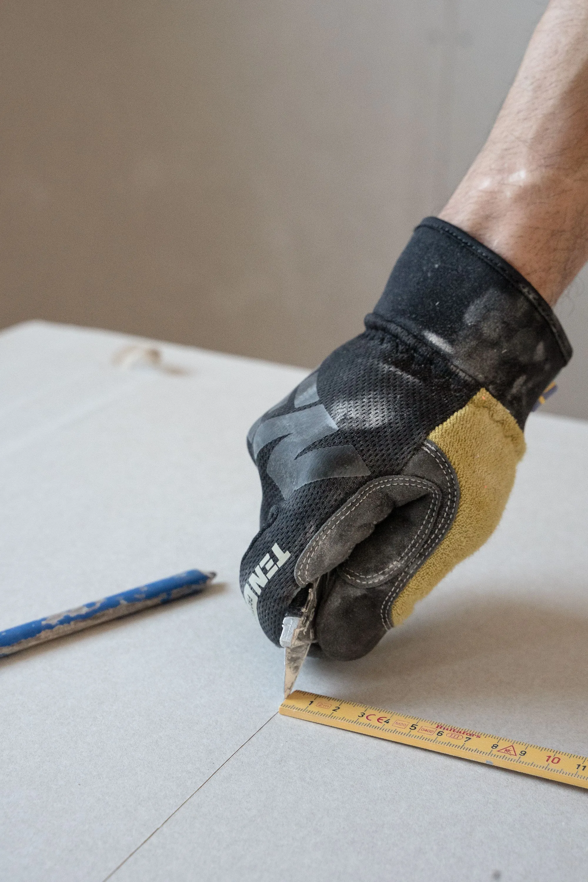 Scoring a sheet of drywall with a utility knife